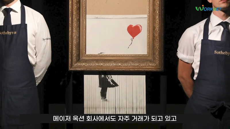 벽에 걸려 있던 그림 아랫 부분이 세로로 잘게 갈렸으며 그 양옆에는 직원들이 서 있는 사진